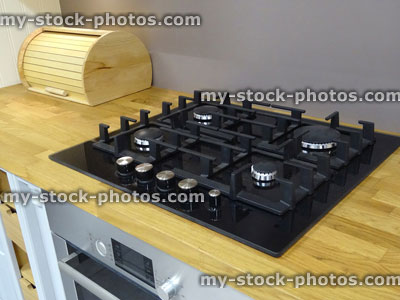 Stock image of traditional kitchen, gas hob, separate electric oven, wooden worktop