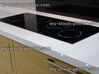 Stock image of modern kitchen, touch electric in line, built in ceramic hob cooker, drawers, wood cabinets
