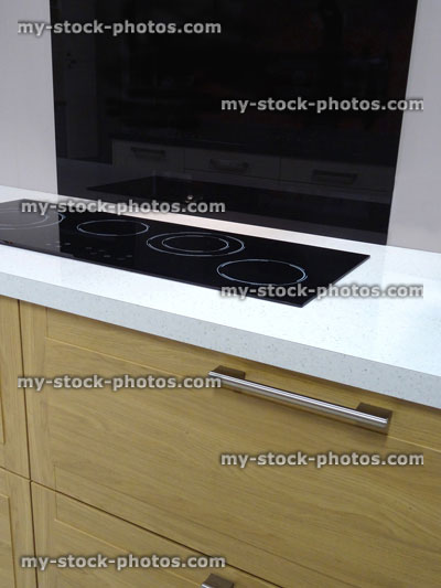 Stock image of modern kitchen, touch electric in line, built in ceramic hob cooker, drawers, wood cabinets