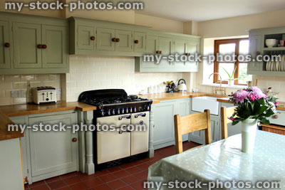 Stock image of traditional country kitchen, gas range cooker, wooden worktops, table, chairs