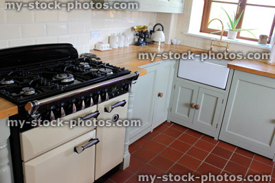 Stock image of traditional country kitchen, gas range cooker, wooden worktops, duck egg cabinets