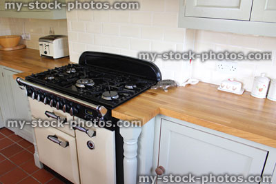 Stock image of traditional country kitchen, gas range cooker, wooden worktops, duck egg cabinets