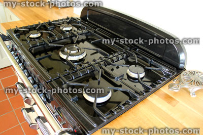 Stock image of traditional country kitchen, range cooker with gas rings, wooden worktops