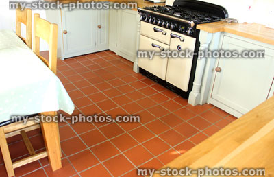 Stock image of traditional country kitchen, gas range cooker, wooden cupboards, tiled floor