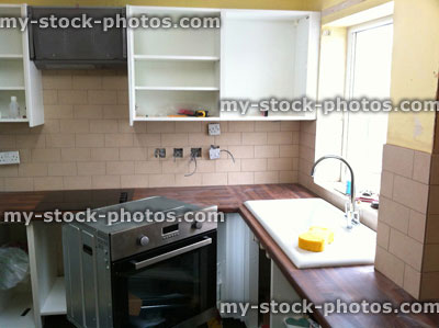 Stock image of new kitchen being fitted, with cooker and cabinets
