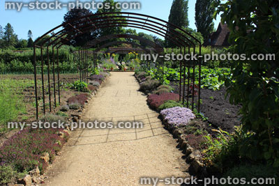 Stock image of kitchen garden signpost / ornamental vegetable garden, metal pergola / arch, climbing plants