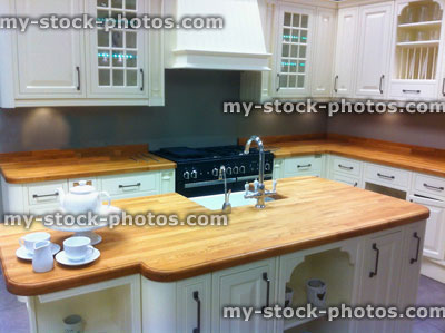 Stock image of traditional white kitchen with island and wooden worktop