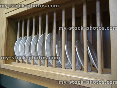 Stock image of wooden plate rack filled with white dinner plates
