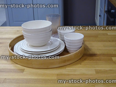Stock image of wooden kitchen worktop counter, plates, cups, saucers, bamboo tray