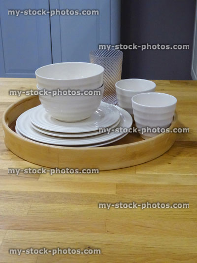 Stock image of wooden kitchen worktop counter, plates, cups, saucers, bamboo tray