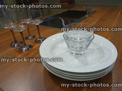 Stock image of wooden kitchen worktop counter, stainless steel sink, plates, wine glasses