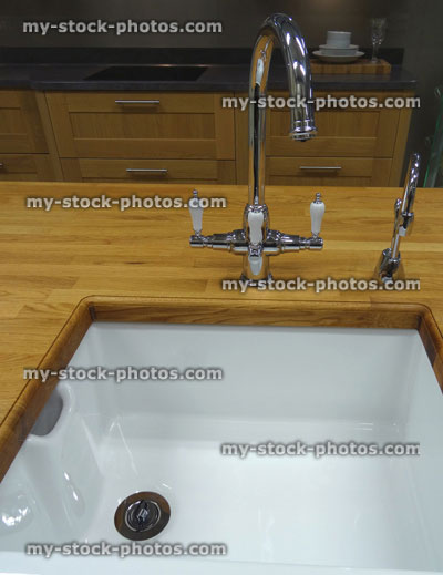 Stock image of traditional kitchen, wooden worktop counter, white ceramic Belfast / Butler sink