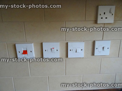 Stock image of cooker / kitchen switches, plug socket, brick tiling, beige / brown wall tiles