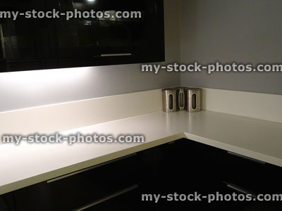 Stock image of kitchen with black cupboards / cabinets and white worktop