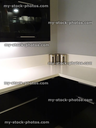 Stock image of black and white kitchen, cabinets with under cupboard lighting