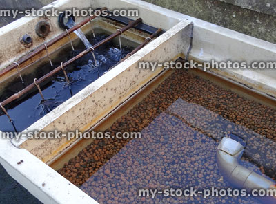 Stock image of plastic garden pond filter / koi carp filtration, brushes and pea gravel