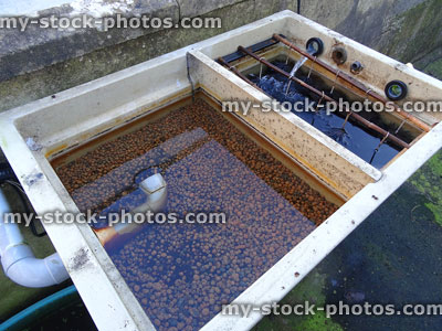 Stock image of plastic garden pond filter / koi carp filtration, brushes and pea gravel