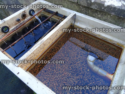 Stock image of plastic garden pond filter / koi carp filtration, brushes and pea gravel