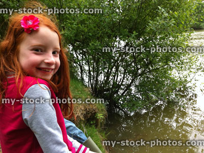 Stock image of girl with flower in hair, next to carp fishing lake