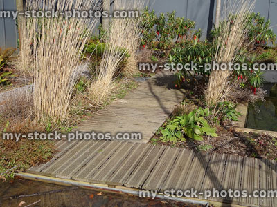 Stock image of non slip / anti slip decking pathway in small garden, dried grasses