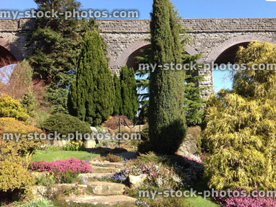 Stock image of cascading waterfall in rockery garden, dwarf conifers, viaduct