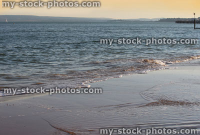 Stock image of orange sunset over glistening sea waves / beach / seaside