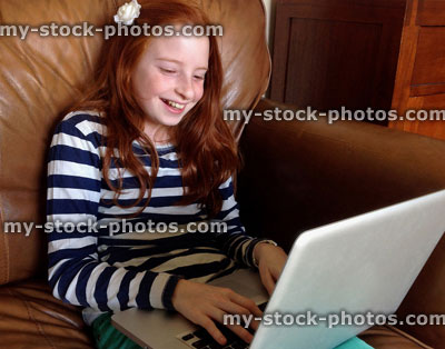 Stock image of girl sitting on sofa using Apple MacBook sofa