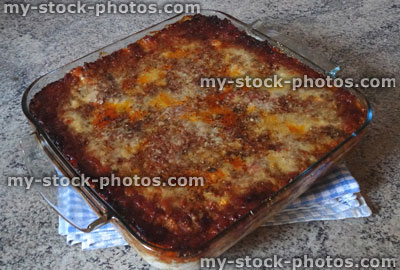 Stock image of cooked lasagne / glass lasagna dish, grated parmesan cheese, vegetarian / meat