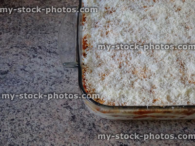 Stock image of prepared homemade lasagne / glass lasagna dish, grated parmesan cheese