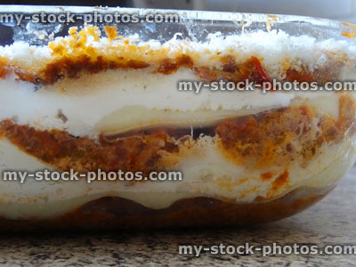 Stock image of homemade vegetarian lasagne / glass lasagna dish, grated parmesan cheese, side view