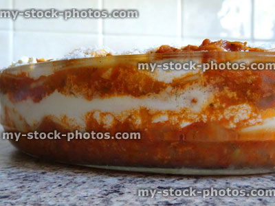 Stock image of homemade vegetarian lasagne / glass lasagna dish, grated parmesan cheese, side view
