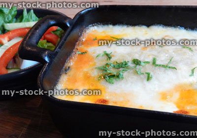 Stock image of lasagne pasta dish, bechamel sauce, melted cheese, salad