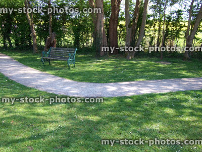 Stock image of shady wooded garden with green lawn, concrete pathway