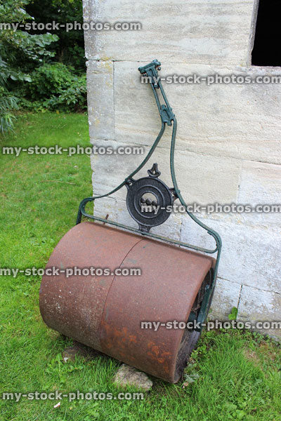 Stock image of rusty, metal, concrete lawn roller, with ornate handle