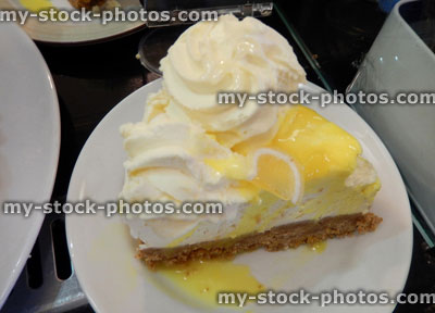 Stock image of lemon chesecake with cream, lemon sauce, indulgent dessert