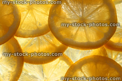 Stock image of lemon slices / overlapping sliced citrus fruit background, backlit