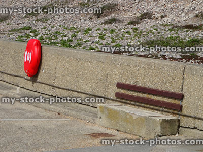 Stock image of red life ring / lifebuoy buoyancy aid on concrete beach wall