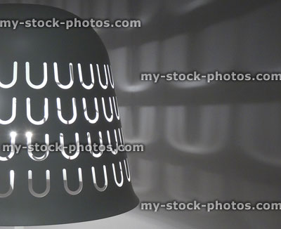 Stock image of bell shape metal lamp shade with light cutouts / shadows