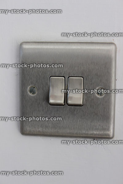 Stock image of stylish, contemporary double stainless steel light switch, square