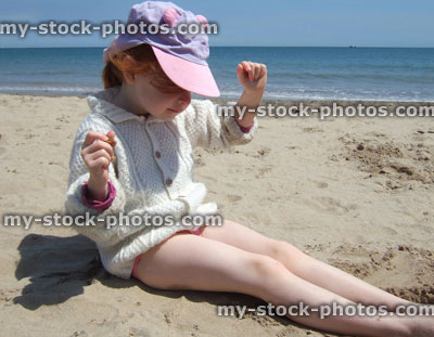 Stock image of little Girl playing in sand on the beach