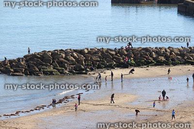 Stock image of sandy seaside beach with children playing in sea