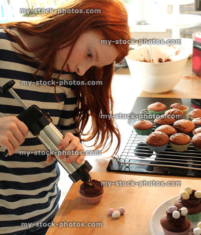 Stock image of girl in a kitchen icing cakes