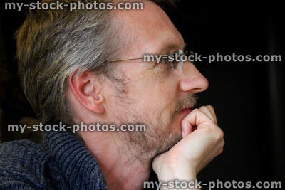 Stock image of ageing middle aged man with grey hair, wrinkles and rimless glasses
