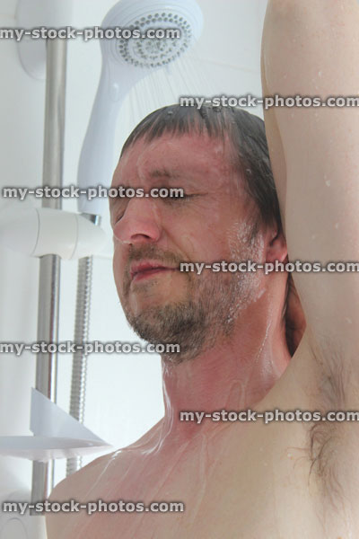 Stock image of young man with beard taking a shower, arm, armpit, face