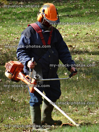 Stock image of man gardening / strimming, cutting grass with petrol strimmer