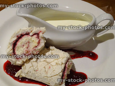 Stock image of homemade raspberry meringue roulade pudding with double cream