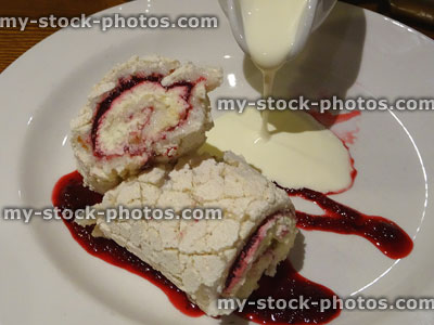 Stock image of sweet dessert, meringue roulade cake with cream / raspberry coulis