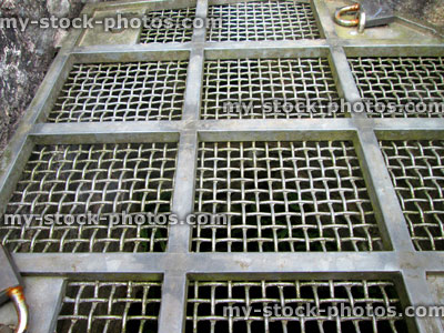 Stock image of galvanised metal grill panels over hole of walkway