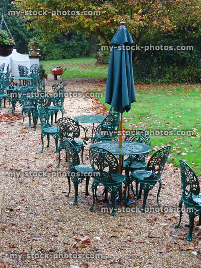Stock image of French style metal green garden furniture, tables chairs, rainy wet English summer