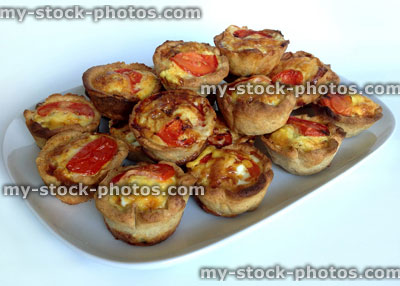Stock image of mini homemade quiches on a white plate 